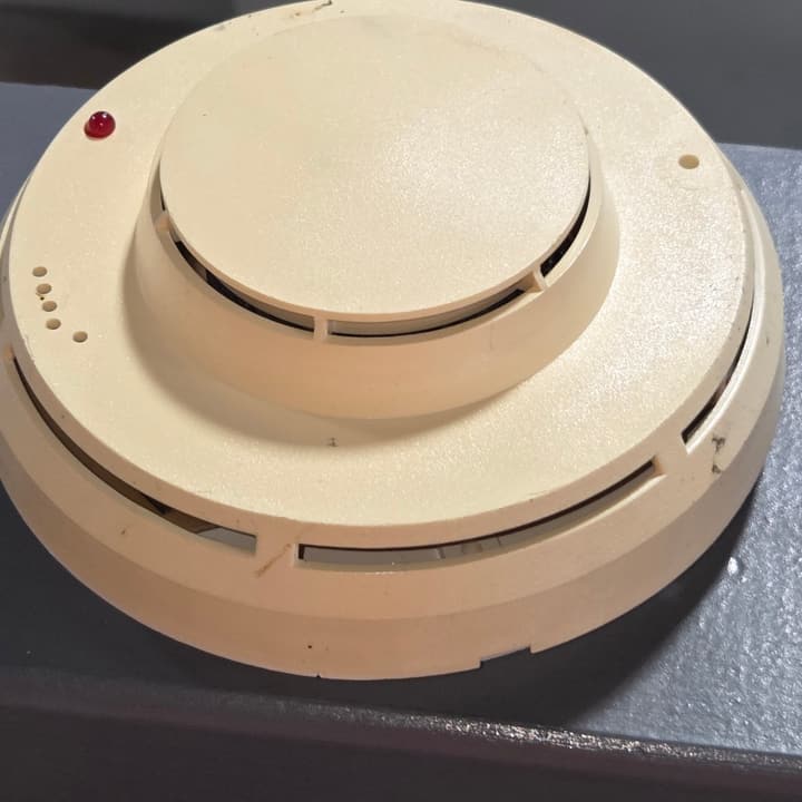 A smoke detector mounted on a commercial ceiling